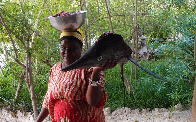 Our cook carries fish to the kitchen